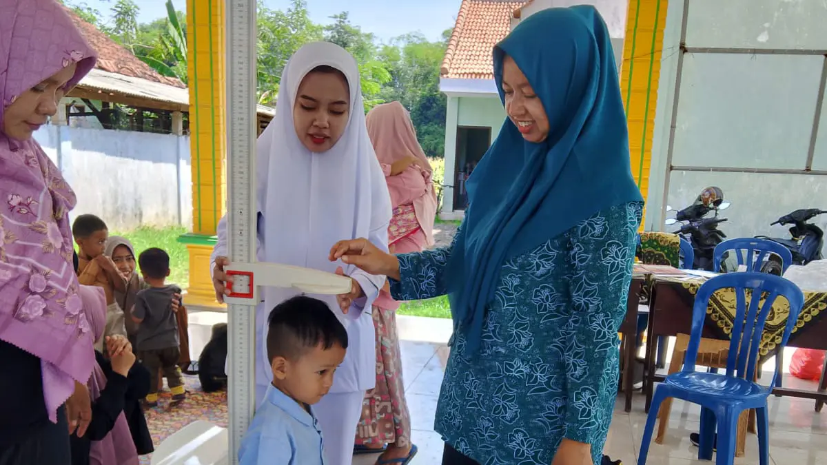 TUMBUH KEMBANG: Ketua PKK Desa Bucor Wetan Isnawati memantau langsung kegiatan Posyandu di Balai Desa Bucor Wetan. (DIDIK PURWANTO/JAWA POS RADAR BROMO)