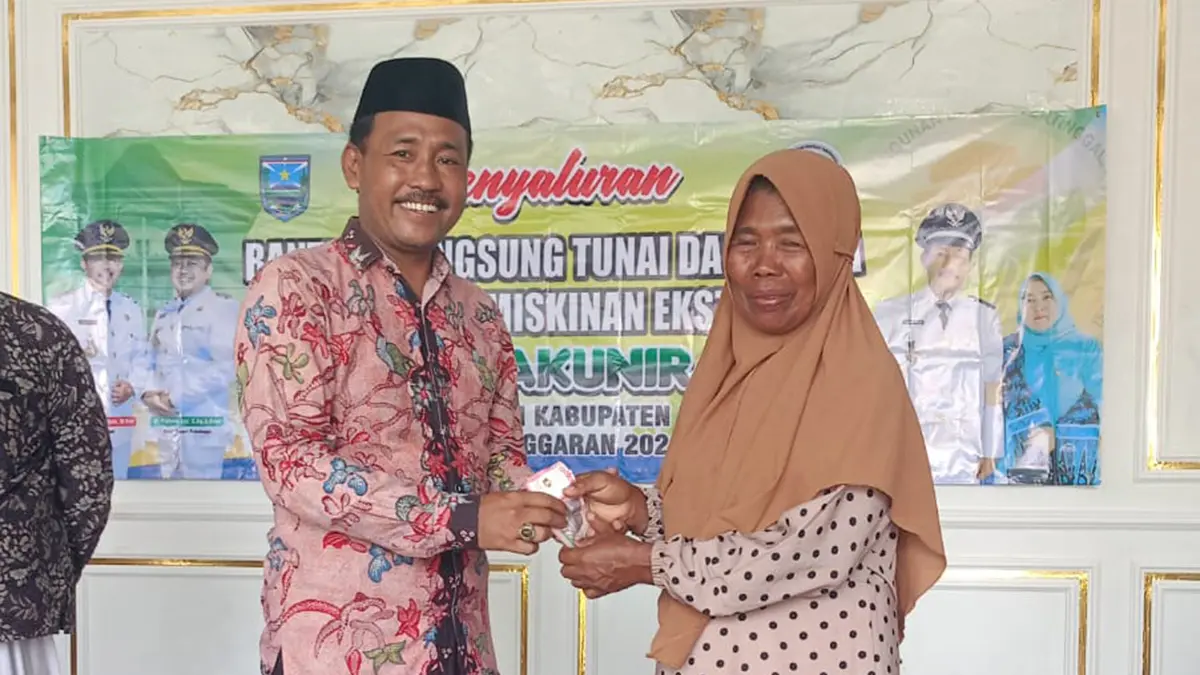 BANTUAN: Kepala Desa Pakuniran Ahmad Fauzi menyerahkan BLT DD Kemiskinan Ekstrim kepada warga penerima manfaat.