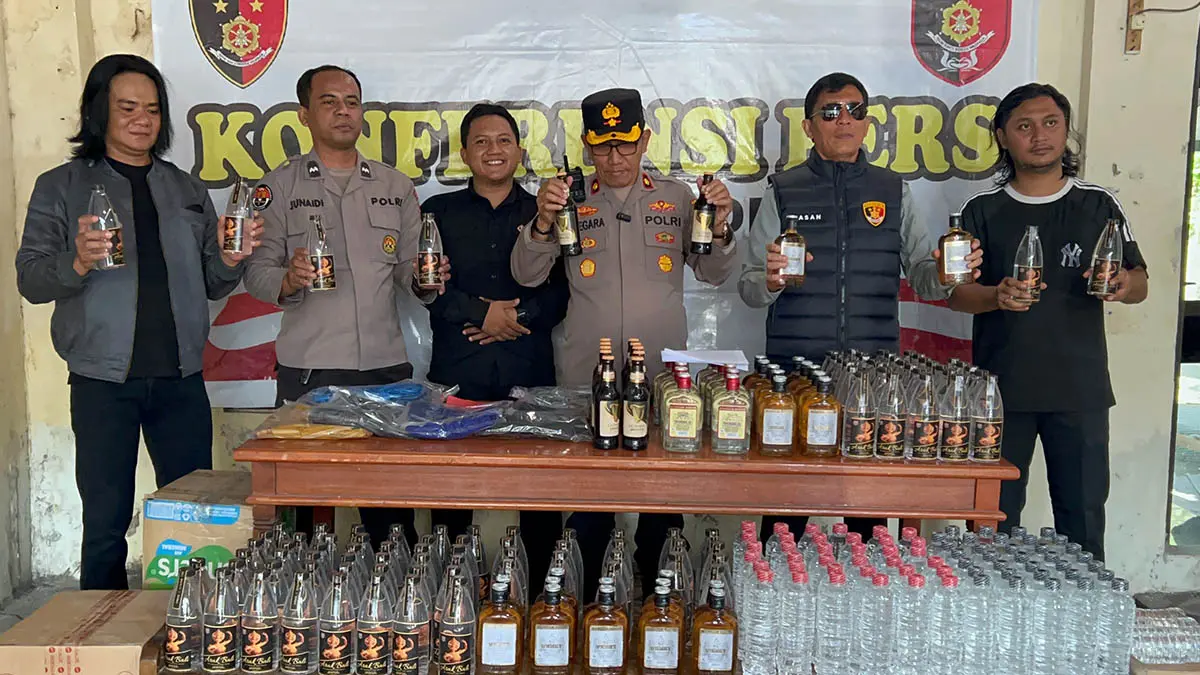 TUNJUKKAN: Pihak kepolisian saat menunjukkan barang bukti miras yang berhasil diamankan. (Fuad Alyzen/Radar Bromo)