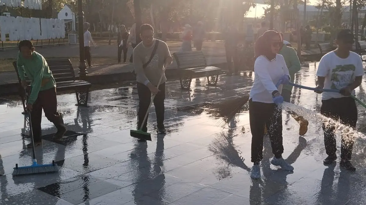 KERJA BAKTI: Sejumlah pegawai Pemkot Probolinggo bersama warga bersih-bersih trotoar Alun-Alun Kota Probolinggo, Rabu (10/6). (ARIF MASHUDI/JAWA POS RADAR BROMO)