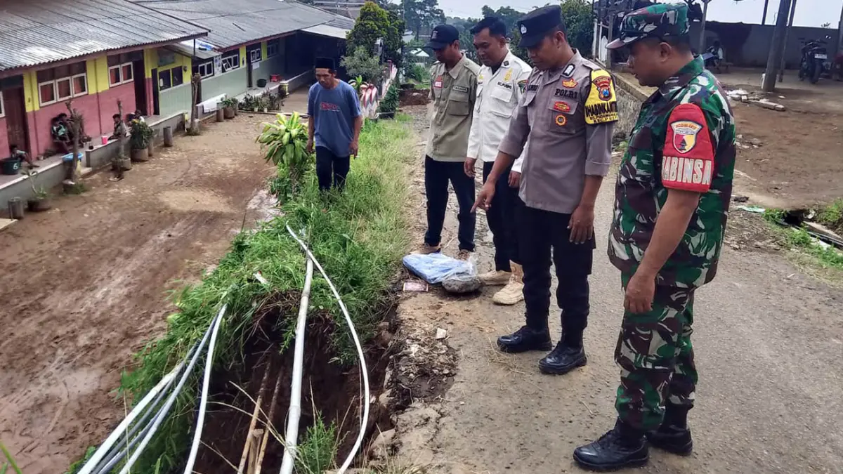 TERGERUS LONGSOR: Jalan Dusun Jeglong, Desa Palangsari, Puspo, Kabupaten Pasuruan, yang longsor pada Jumat (12/6) sore ditutup terpal.