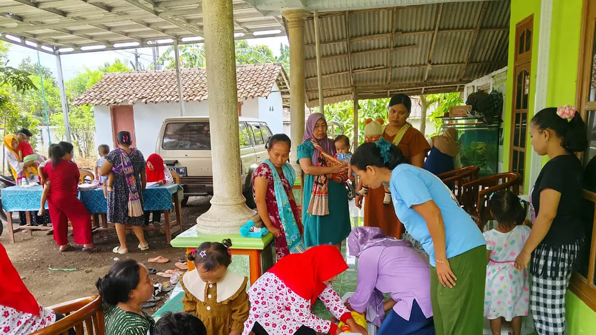 ANTUSIAS: Ibu-ibu antusias mengajak anaknya mengikuti kegiatan posyandu balita di Dusun Krajan, Desa Glagah. (Foto : Didik Purwanto/Jawa Pos Radar Bromo)