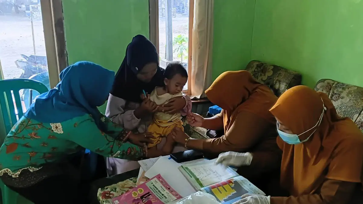BALITA SEHAT: Bidan bersama Kader Posyandu memberikan vaksin kepada seorang balita dalam kegiatan Posyandu di Dusun Krajan. (Foto : Didik Purwanto/Jawa Pos Radar Bromo)