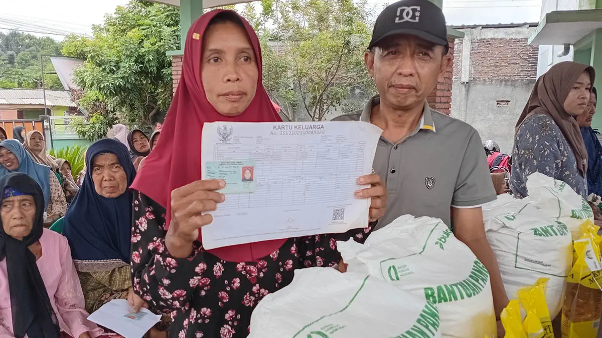 BANTUAN PANGAN: Kepala Desa Glagah Abdur Rahman membersamai penerima bantuan pangan dipendopo Desa Glagah. (Foto : Didik Purwanto/Jawa Pos Radar Bromo)