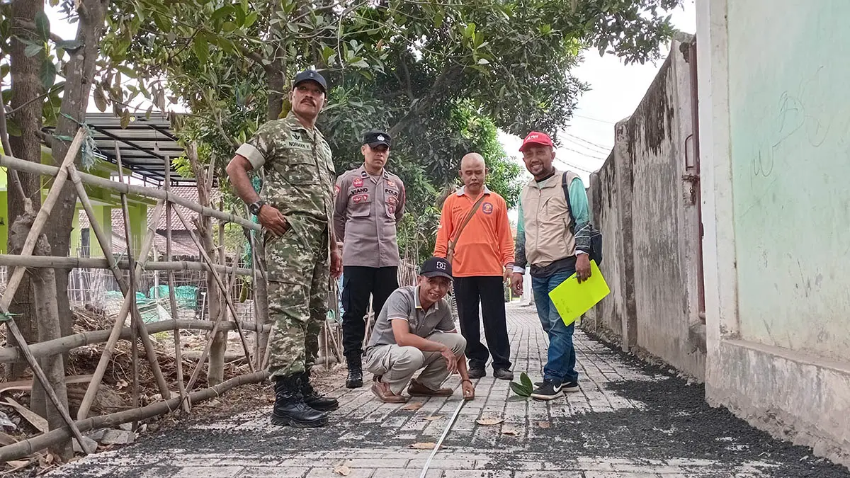 UKUR LANGSUNG: Kepala Desa Glagah Abdur Rahman (jongkok) bersama Tim Monev di lokasi Pembangunan Pavingisasi Dusun Krajan RT/RW 3/1. (Foto : Didik Purwanto/Jawa Pos Radar Bromo)