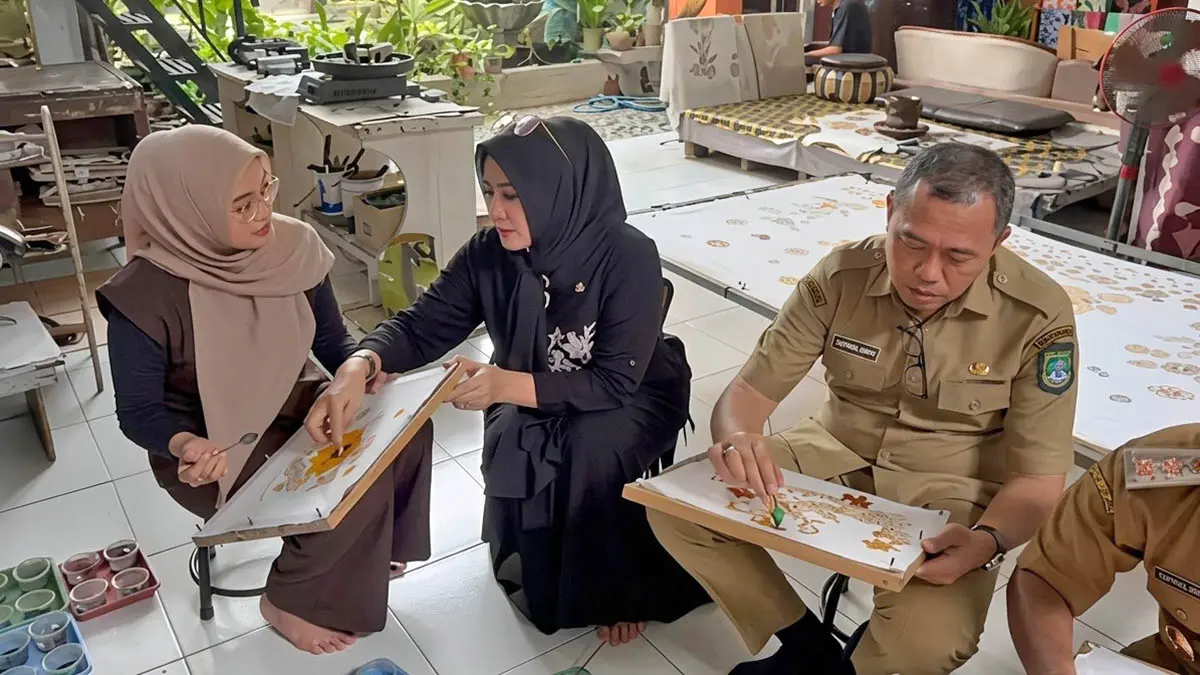 MEMBATIK: Ketua TP PKK Kabupaten Pasuruan Merita Ariestya saat meninjau langsung sentra batik tulis di Cangkringmalang, bersama Kepala Diskoperindag Taufikhul Ghony. Dalam kesempatan itu, Mela-sapaan Merita Ariestya ikut membatik. (Muhamad Busthomi/Radar Bromo)