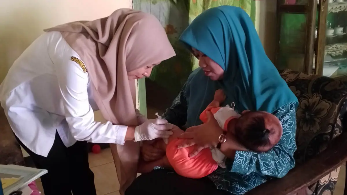 KAWAL POSYANDU: Ismawati Ketua PKK Desa Kalidandan saat pemberian vaksin kepada Balita, kegiatan posyandu di Dusun Krajan. (Foto: Didik Purwanto/Jawa Pos Radar Bromo)