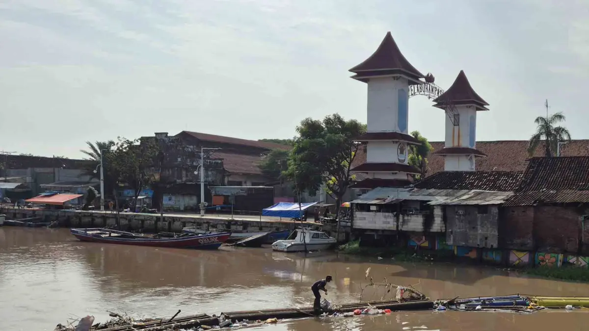 Atas sampah: Seorang petugas dari SDA membersihkan sampah di aliran Sungai Gembong, Kota Pasuruan, beberapa waktu lalu. (DOK. JAWA POS RADAR BROMO)