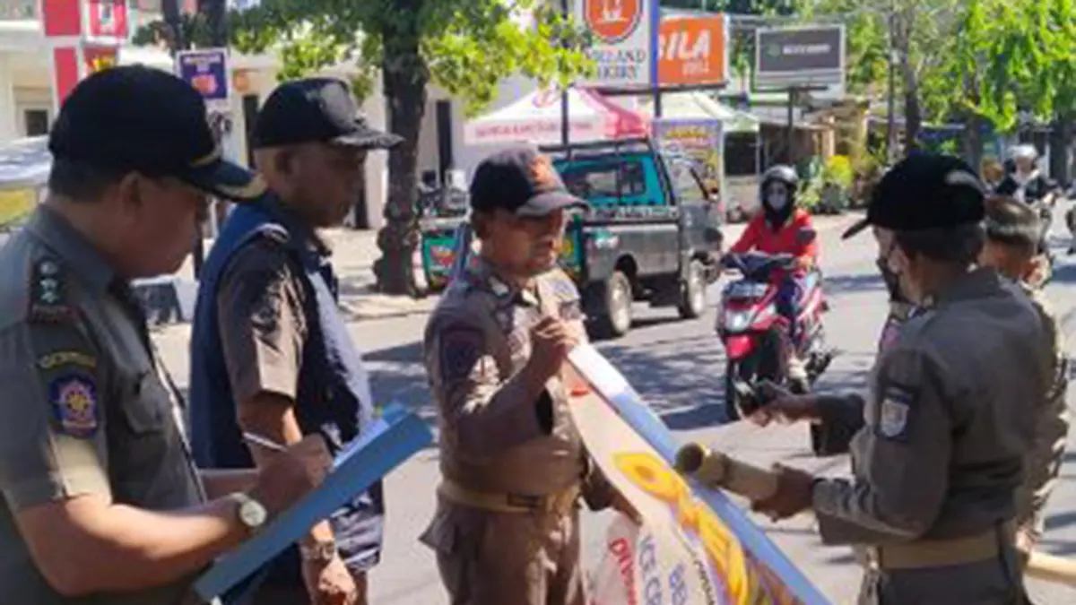 COPOT: Anggota Satpol PP Kota Probolinggo menertibkan reklame di Jalan Cokroaminoto, Kota Probolinggo, Rabu (17/6). (SATPOL PP KOTA PROBOLINGGO FOR JAWA POS RADAR BROMO)
