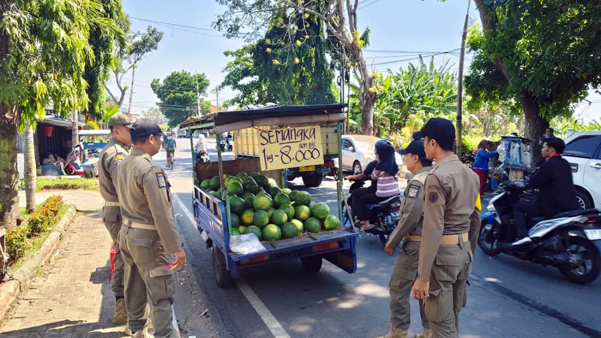 DITINDAK: Anggota Satpol PP Kota Probolinggo menghalau pedagang buah di depan Kantor Disdikbud Kota Probolinggo, Rabu (17/11).
