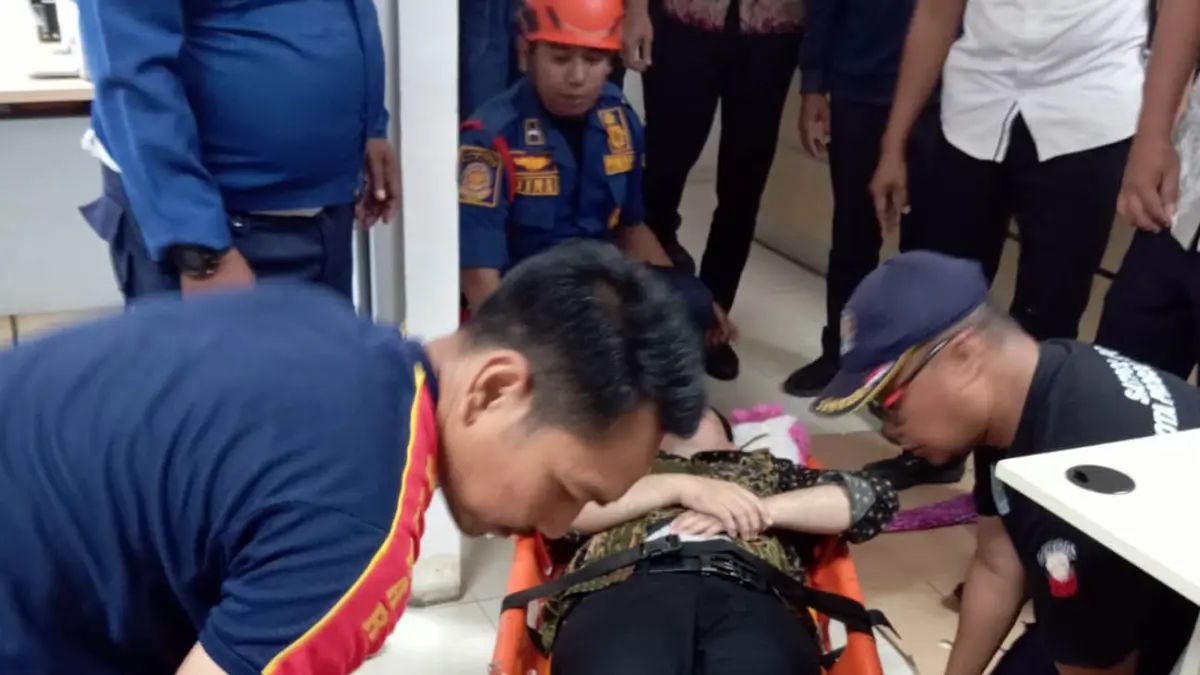 EVAKUASI: Tim Damkar Satpol PP Kota Probolinggo mengevakuasi karyawan sebuah bank yang pingsan di lantai dua, (17/9).