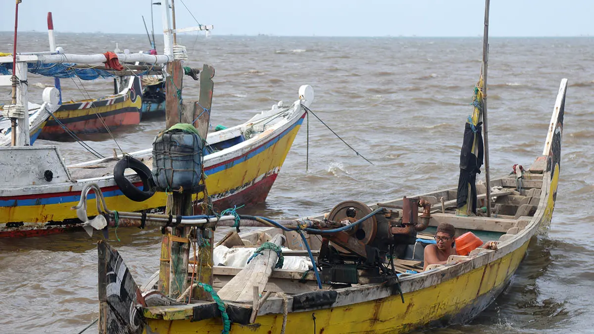 HARUS PANTAU CUACA: Nelayan di pesisir Lekok membersihkan perahunya saat libur melaut. BMKG memperkirakan ombak perairan di Jawa Timur bakal tinggi sampai 21 Juni mendatang. (Foto: M Zubaidillah/Jawa Pos Radar Bromo)
