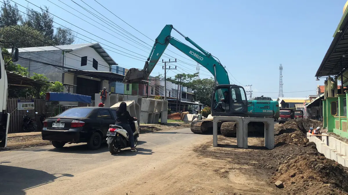DIKEBUT: Sebuah ekskavator saat mengangkat U-ditch di Jalan Lingkar Utara, Kecamatan Mayangan, Kota Probolinggo, Senin (22/6). (Inneke Agustin/ Radar Bromo) 
