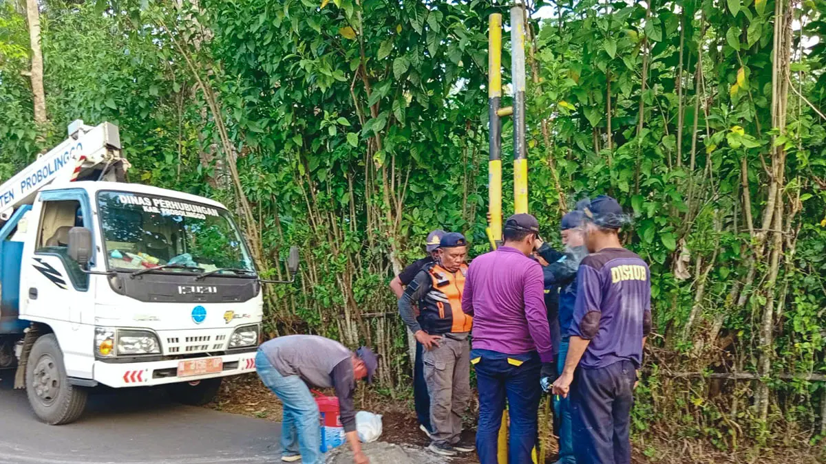 DIPASANG: Petugas memasang portal sementara di Dusun Kedungkokap, Desa Segaran, Kecamatan Tiris. Dinas Perhubungan bertahap memasang portal. (Foto: dok Jawa Pos Radar Bromo)