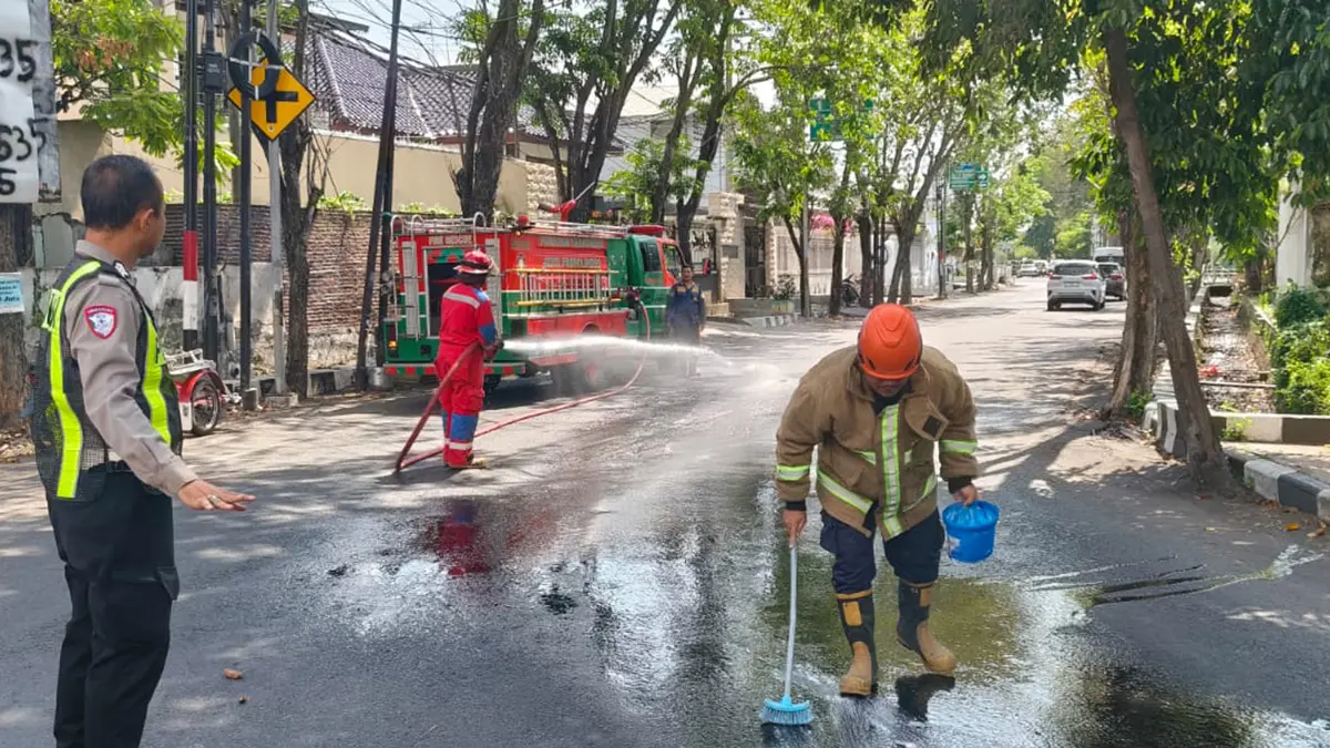 EVAKUASI: Tim Damkar Satpol PP Kota Probolinggo membersihkan ceceran solar di Jalan Pahlawan, Kota Probolinggo, Sabtu (20/6). (DAMKAR SATPOL PP KOTA PROBOLINGGO FOR JAWA POS RADAR BROMO)