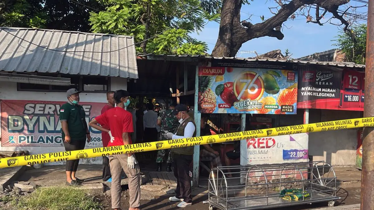 POLICE LINE: Petugas saat hendak mengevakuasi jenazah Andika Wahyu Santoso, seorang manusia silver yang ditemukan tewas dengan luka di kepala di belakang warung sekitar simpang empat Pilang, Kota Probolinggo. (Inneke Agustin/ Radar Bromo)