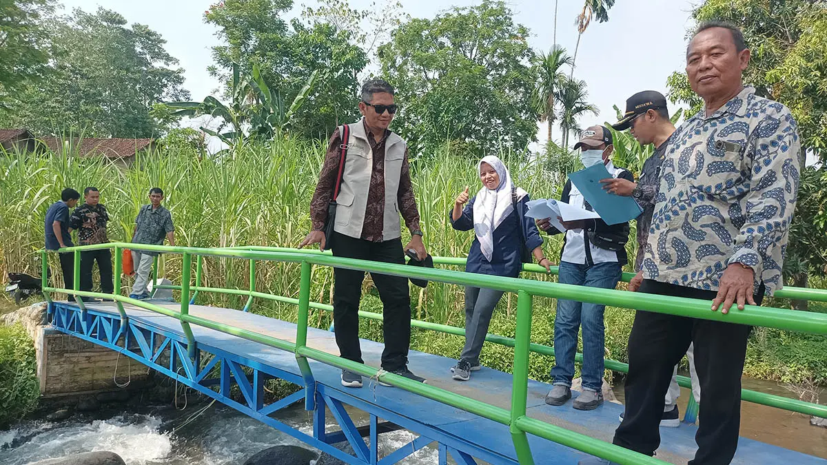 RAMPUNG: Kepala Desa Bago, Drs Nawawi (kanan) saat berada di lokasi jembatan yang tuntas digarap.