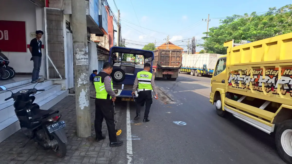 PENYELIDIKAN: Petugas kepolisian saat melakukan olah TKP untuk mengumpulkan alat bukti atas kasus kecelakaan yang menewaskan Satoli, warga Kraton, Kabupaten Pasuruan. 