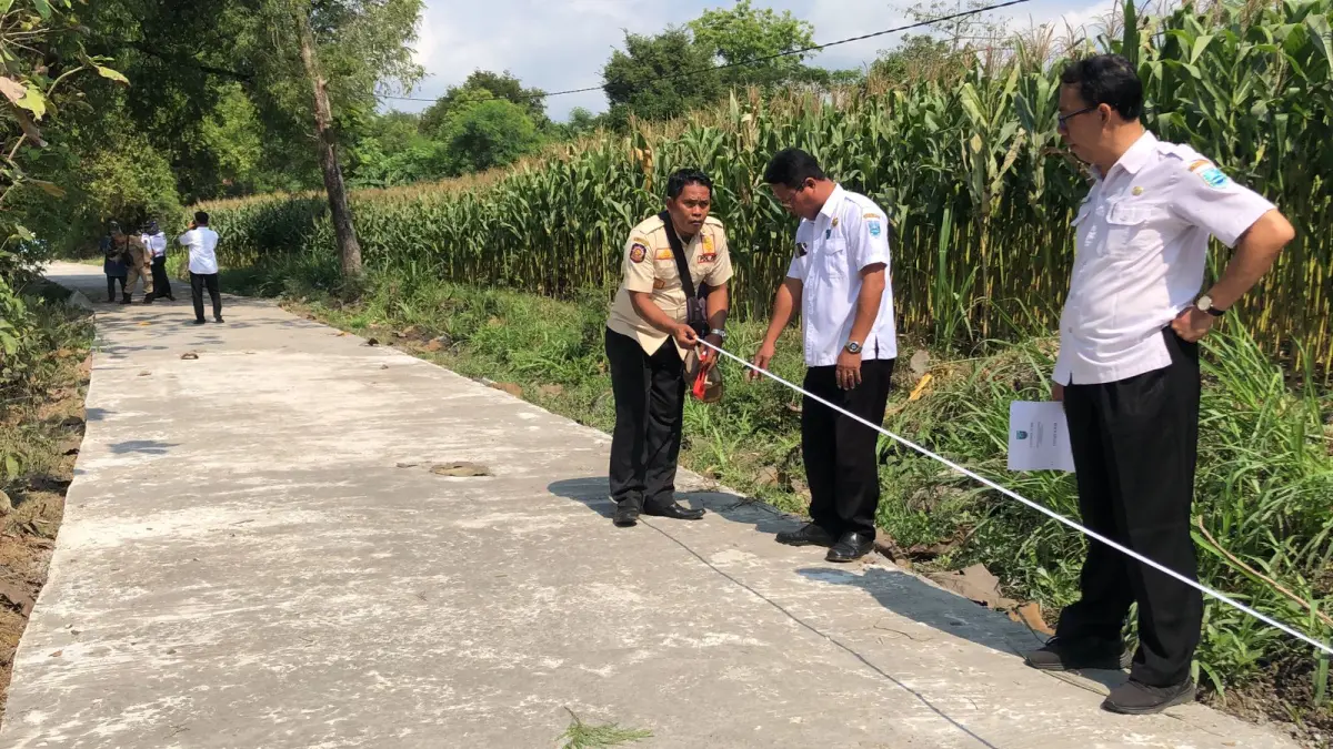 MONEV: Sekretaris Kecamatan Tongas Agus Subairi (dua dari kanan) bersama Perangkat Kecamatan Tongas melakukan monev pembangunan jalan rabat beton di Dusun Somor Kodung, Desa Sumberrejo.