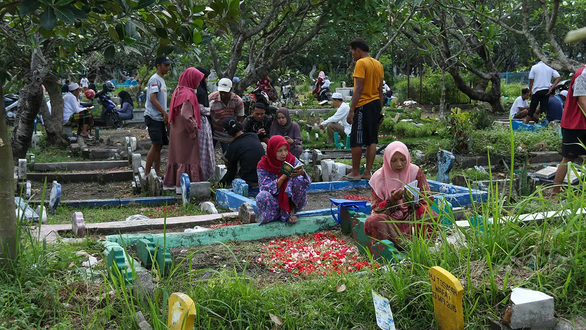 BERZIARAH: Lebaran identik juga dengan berziarah kubur. Tak heran, banyak masyarakat Pasuruan yang datang ke makam kerabat, saudara ataupun orang tua, untuk mendoakan mereka. (Mokhamad Zubaidillah/Radar Bromo)