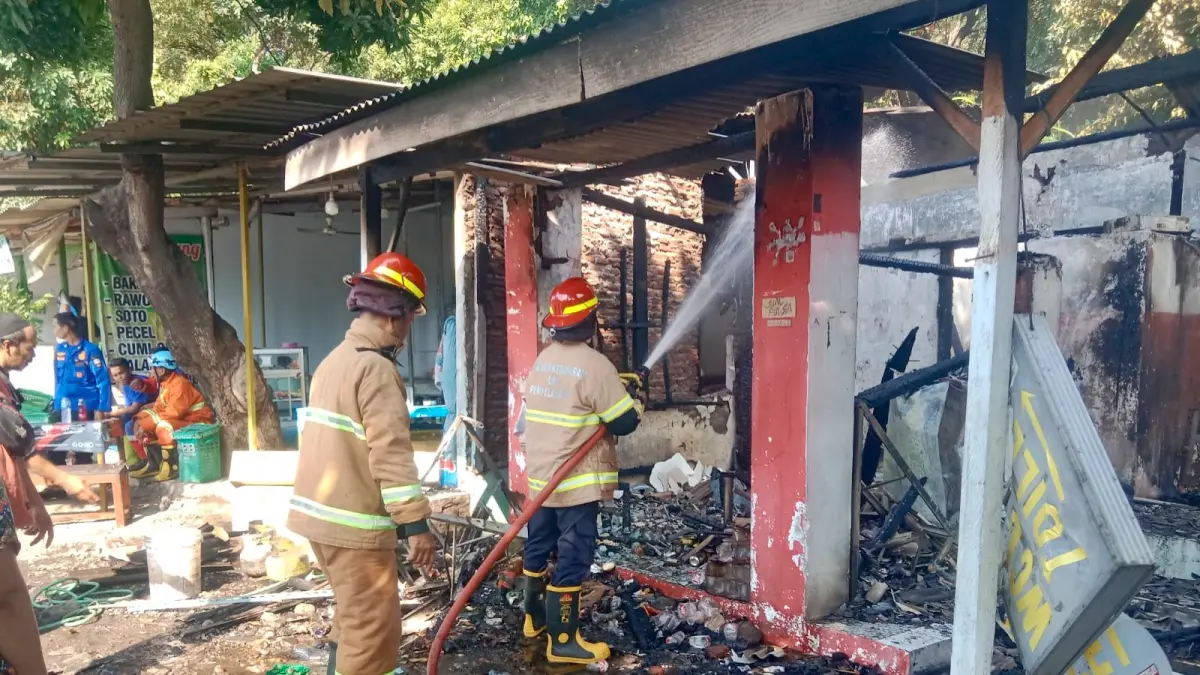HANGUS: Tim Damkar Kabupaten Probolinggo melakukan pemadaman api yang membakar dua warung makan di Desa Binor, Kecamatan Paiton. (DAMKAR FOR JAWA POS RADAR BROMO)