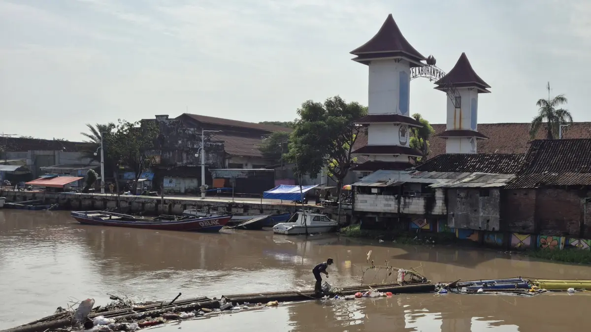 DIBERSIHKAN: Salah seorang petugas SDA membersihkan aliran Sungai Gembong dari sampah. (FAHRIZAL FIRMANI/JAWA POS RADAR BROMO)