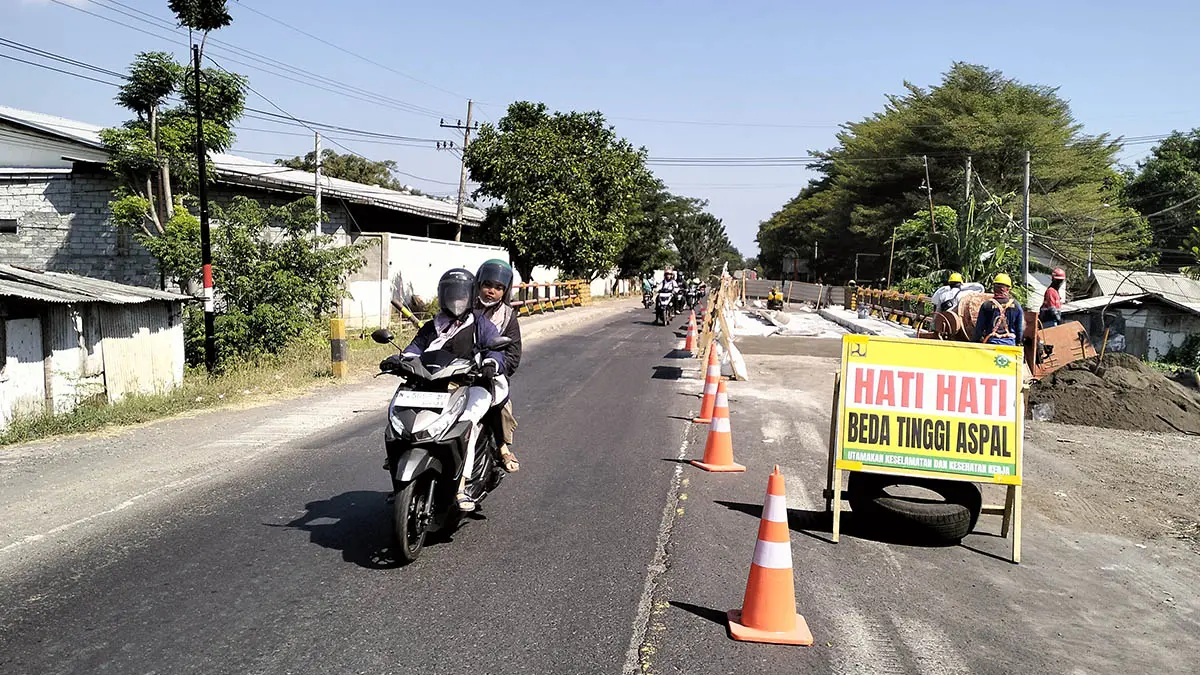 DIKEBUT: Pengendara motor melintas di jembatan Matikan II di ruas jalan pantura Desa Sumberanyar, Kecamatan Paiton yang masih dalam proses pembetonan di ruas sisi kiri. (Foto : Achmad Arianto/Jawa Pos Radar Bromo)