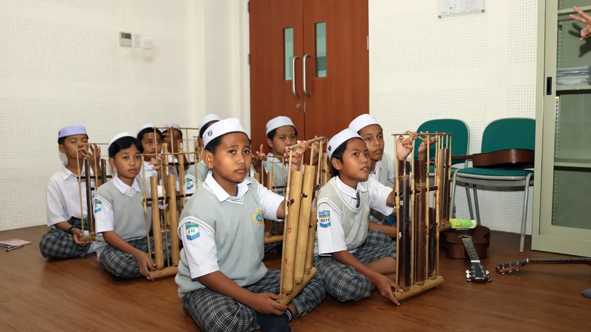 Sejumlah siswa belajar memainkan alat musik tradisional. 