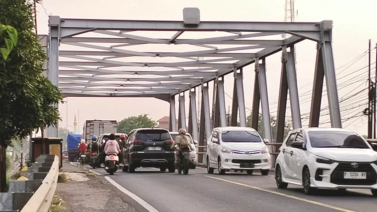 BAKAL DIBONGKAR: Pengguna jalan melintasi jembatan pajarakan. Jembatan ini bakal dibongkar total karena tak lagi kokoh. (Foto: Achmad Arianto/Jawa Pos Radar Bromo)
