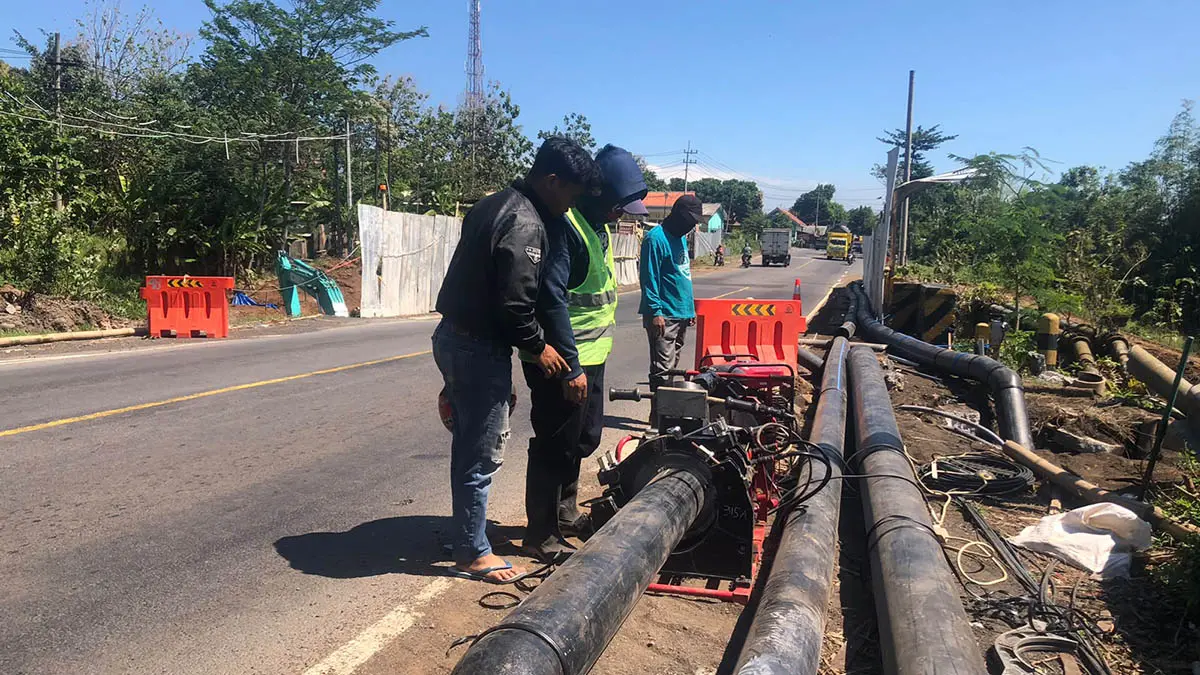 PROYEK: Sejumlah pekerja Perumdam Tirta Argapura berusaha membuat jalur air sementara di Jalan Raya Lumajang, Desa Malasan Kulon, Kecamatan Leces, Senin (29/6). (Inneke Agustin/Radar Bromo)