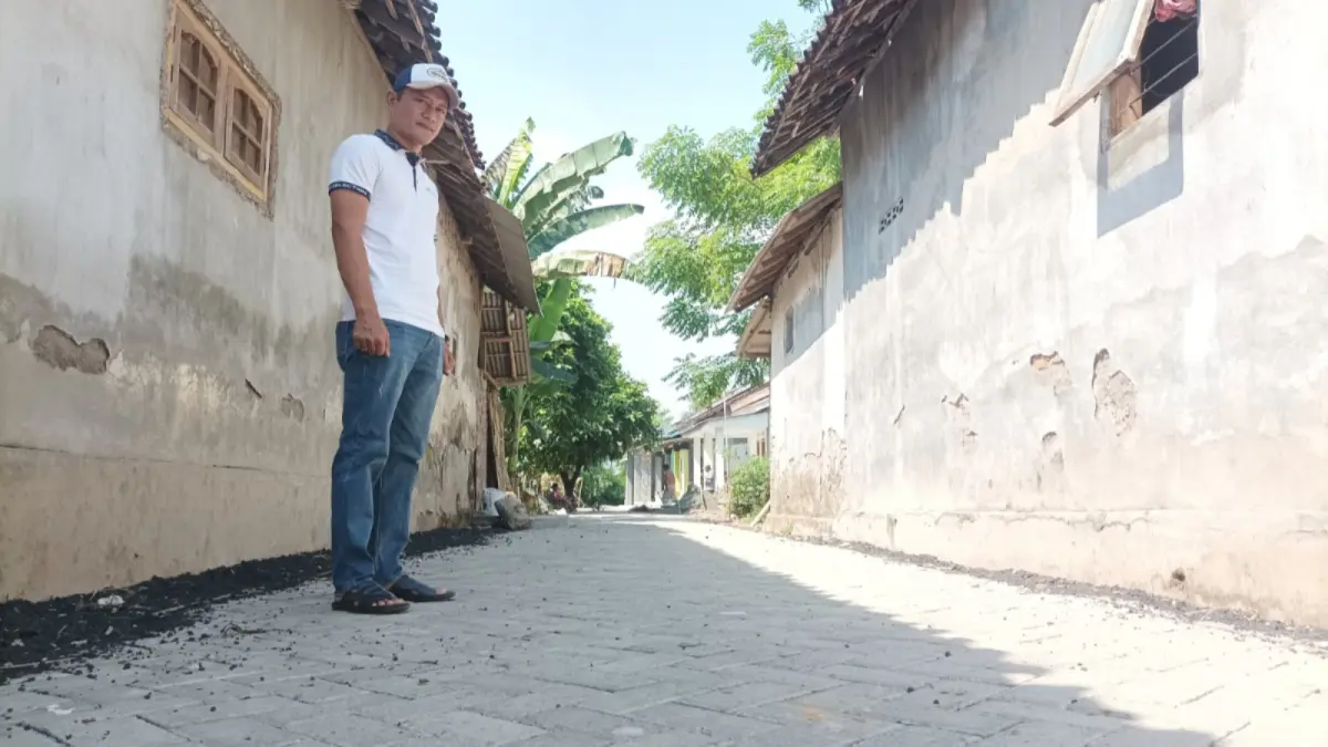 LEBIH BAIK: Kepala Desa Alassumur Lor Mulyono mengecek hasil pembangunan jalan paving. (AGUS FAIZ MUSLEH/JAWA POS RADAR BROMO)