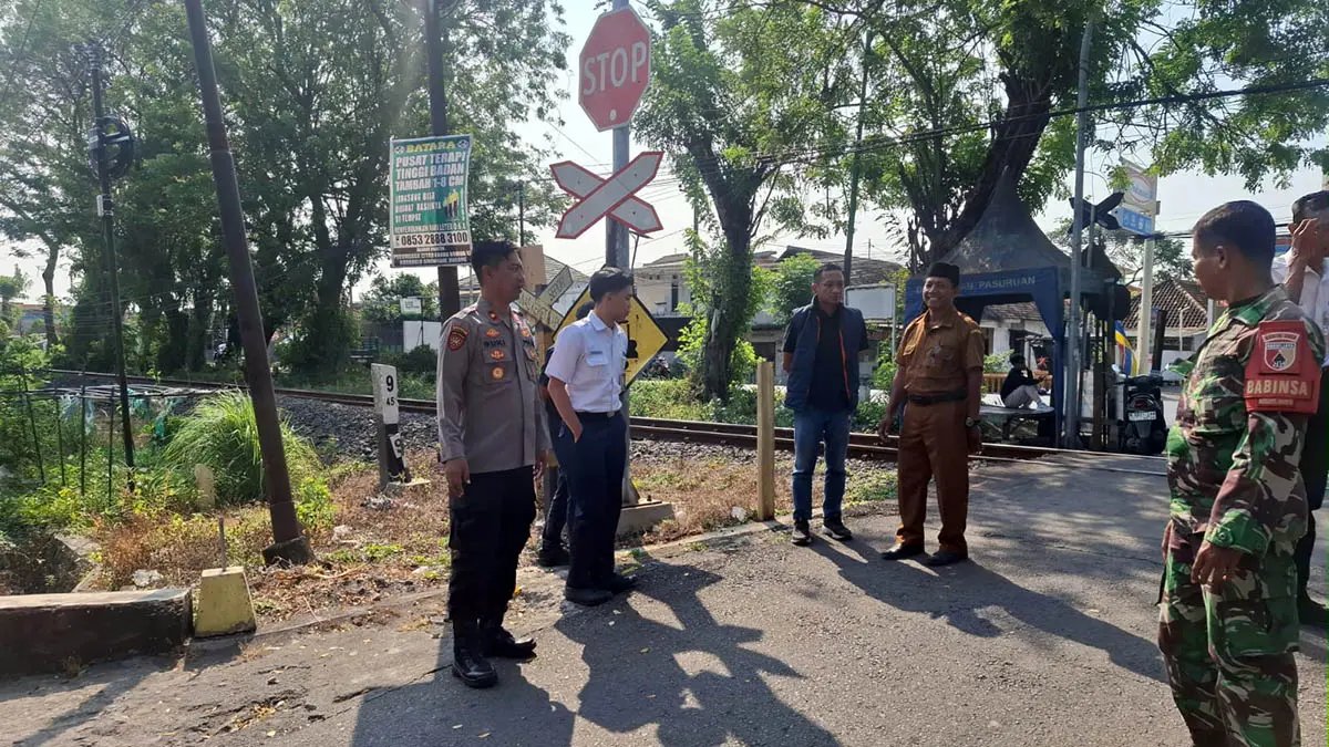 SURVEI: Petugas gabungan saat melakukan survei di perlintasan KA Gajahbendo, Kecamatan Beji, Kabupaten Pasuruan. Rencana penutupan jalur setempat, batal. Dan hanya akan dipasangi patok. (Polsek Beji for Radar Bromo)