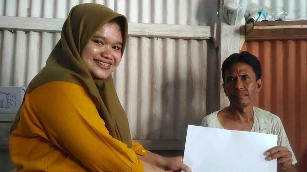 BANTU WARGA: Ketua Tim Penggerak PKK Desa Besuk Agung Veni Nasir menyerahkan BLT DD kepada salah satu KPM.