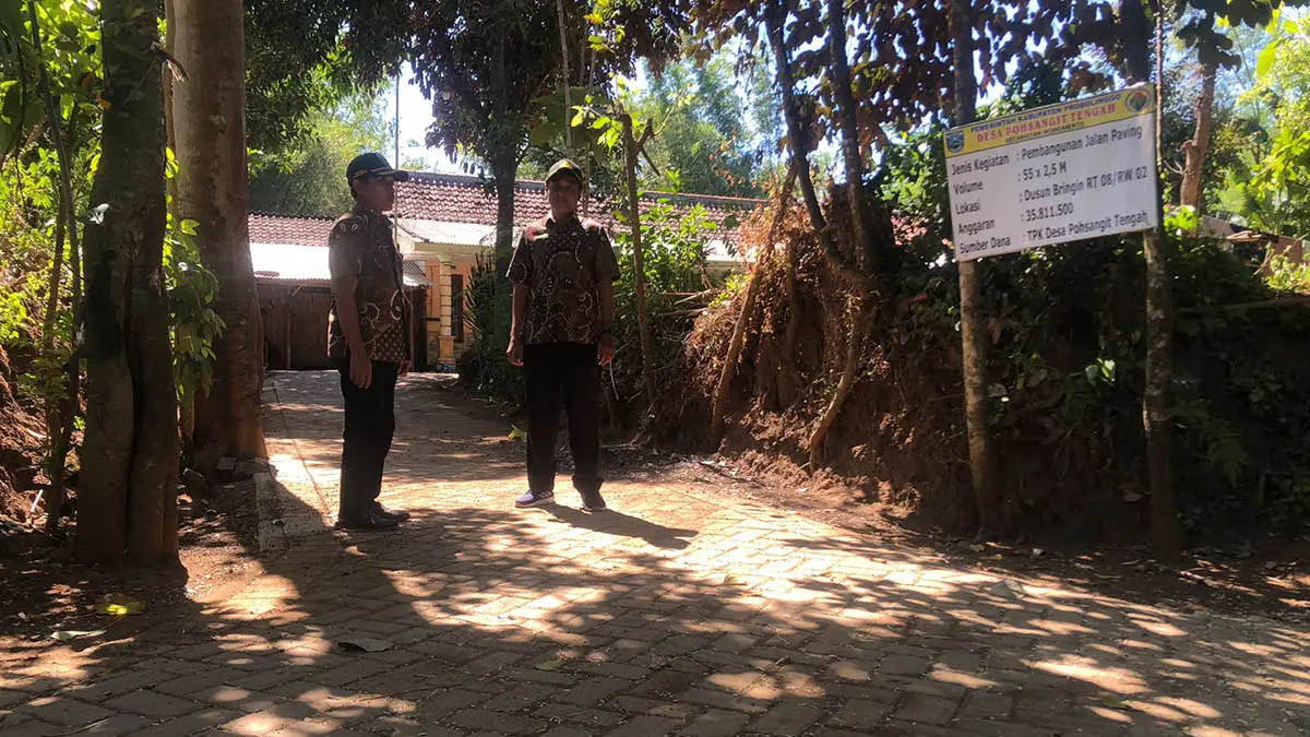 NYAMAN: Sekretaris Desa Pohsangit Tengah, Suyono (kiri) saat mengecek jalan paving di Desa Pohsangit Kidul, Kecamatan Wonomerto. (Foto: Inneke Agustin/Jawa Pos Radar Bromo)