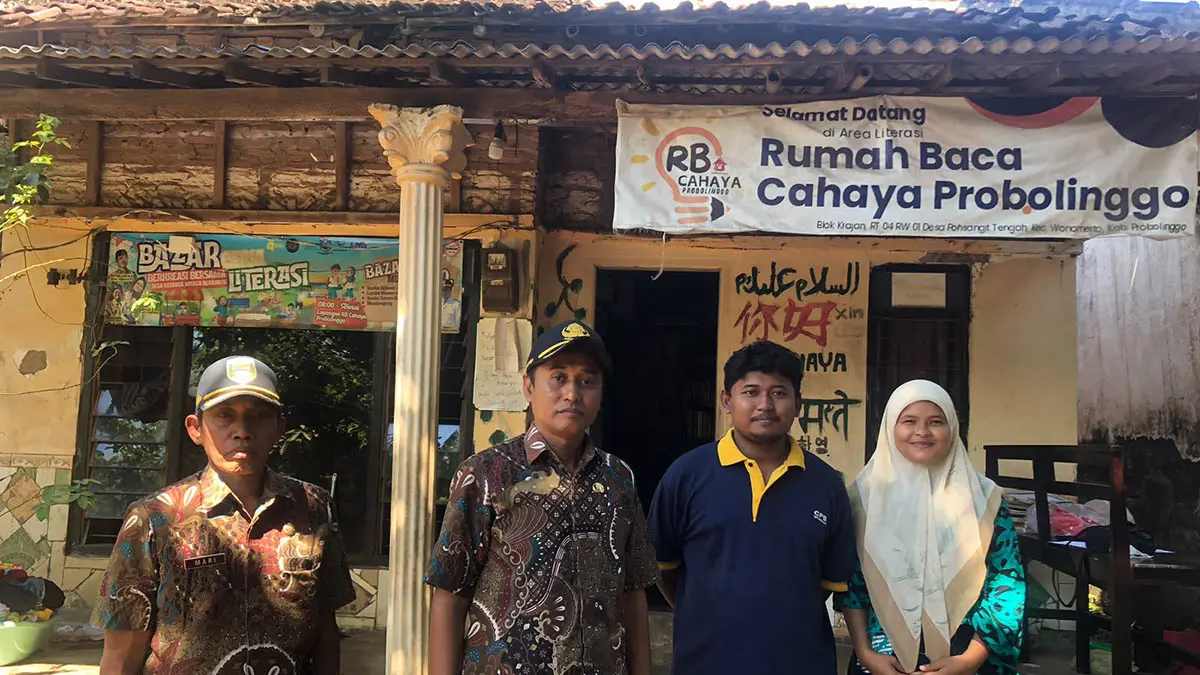 SENANG: Sekretaris Desa Pohsangit Tengah, Suyono (dua dari kiri) bersama pendiri Taman Baca Cahaya, Desa Pohsangit Kidul, Kecamatan Wonomerto. (Foto: Inneke Agustin/Jawa Pos Radar Bromo)