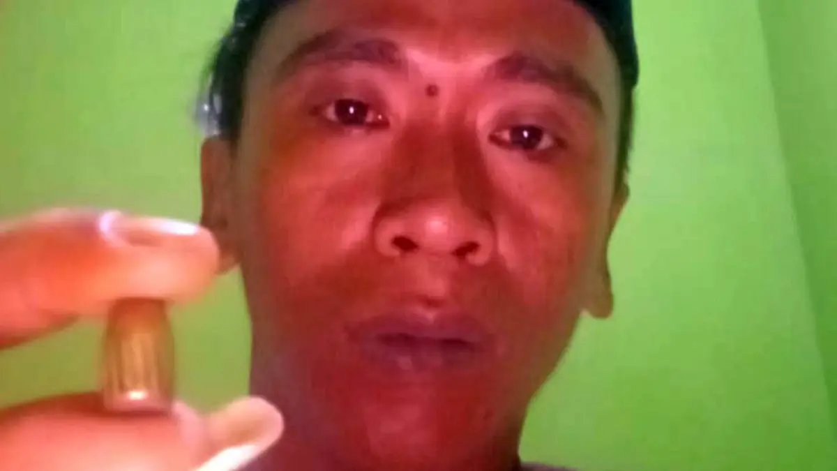 Sulihin menunjukkan peluru nyasar yang menembus atap rumahnya. 