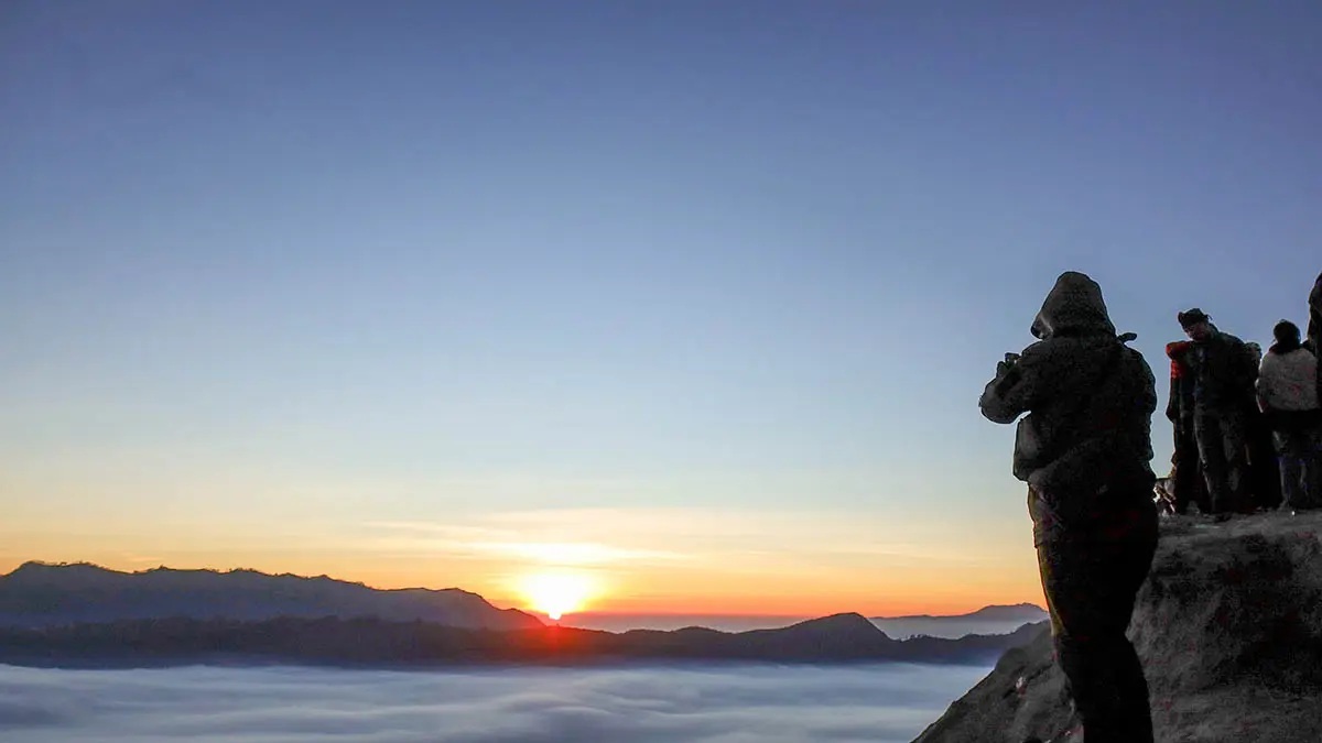 DESTINASI FAVORIT: Wisatawan saat menikmati momen matahari terbit dari puncak Gunung Bromo. Selama libur sekolah, sudah puluhan ribu wisatawan yang datang ke Bromo. (Foto: M Zubaidillah/Jawa Pos Radar Bromo)