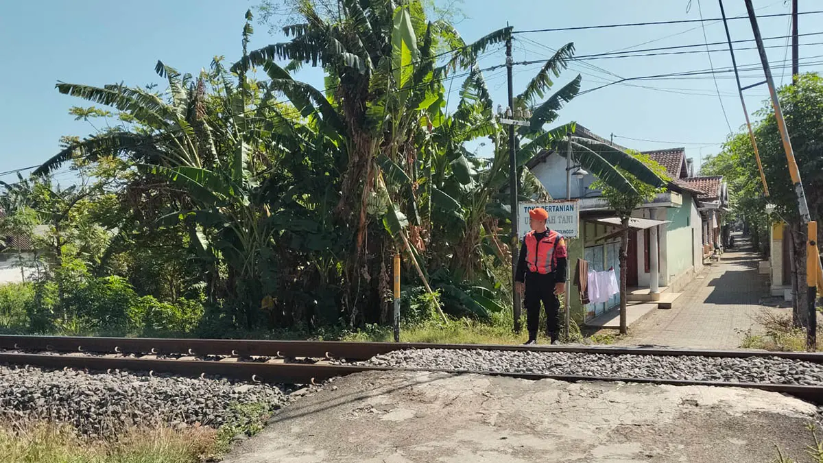 STAND BY: Petugas penjaga di jalur perlintasan langsung Jalan Leces – Probolinggo. Selama liburan, PT KAI menempatkan petugas tambahan untuk berjaga. (Foto: Arif Mashudi/Jawa Pos Radar Bromo)