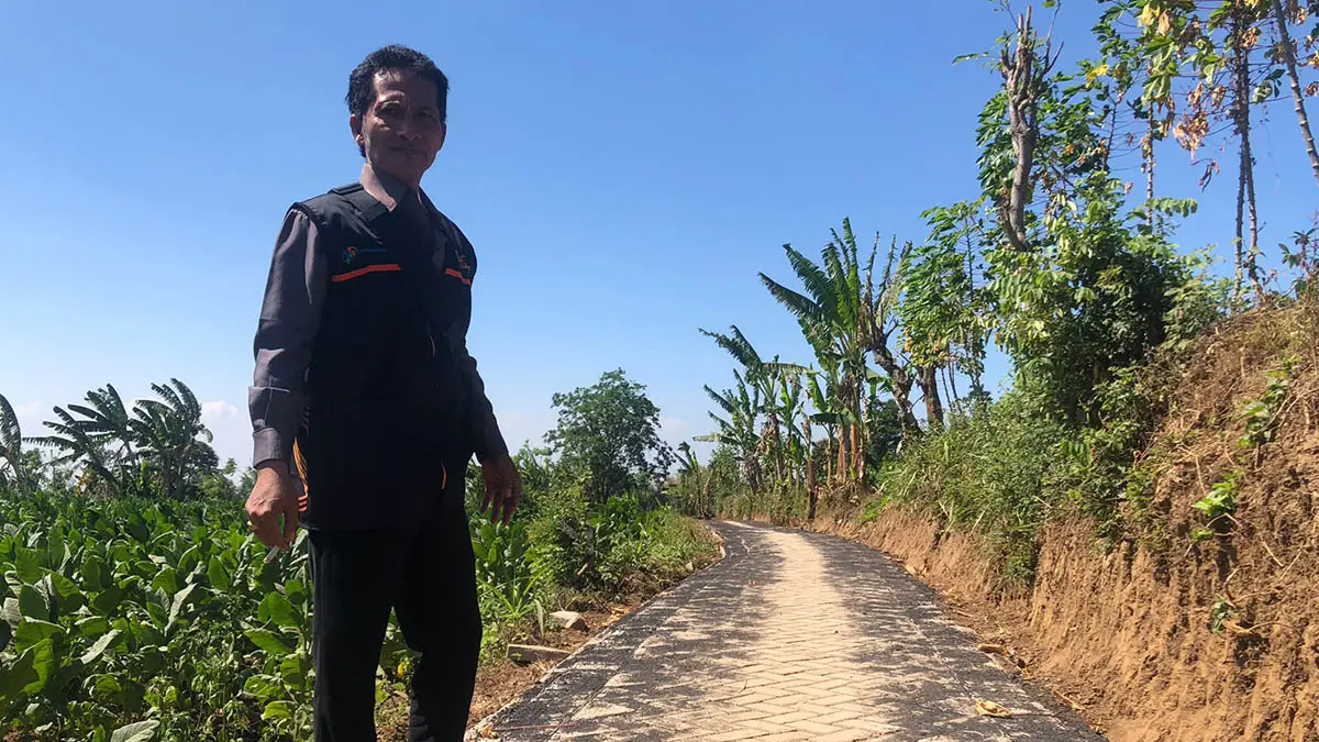 LEBIH NYAMAN: Kasi Pembangunan Desa Patalan, Budiono di lokasi pavingisasi jalan di Dusun Sungai Tengah, Desa Patalan, Kecamatan Wonomerto. Jalan yang berada di Dusun Sungai Tengah ini dibangun sepanjang 195 meter. (Foto: Inneke Agustin/Jawa Pos Radar Bromo)