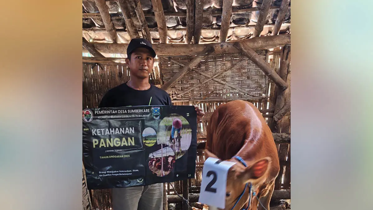 SENANG: Sekretaris Desa Sumberkare Rohmat (kanan) menyalurkan BLT DD kepada salah satu warganya di Desa Sumberkare. (Foto: Inneke Agustin/Jawa Pos Radar Bromo)