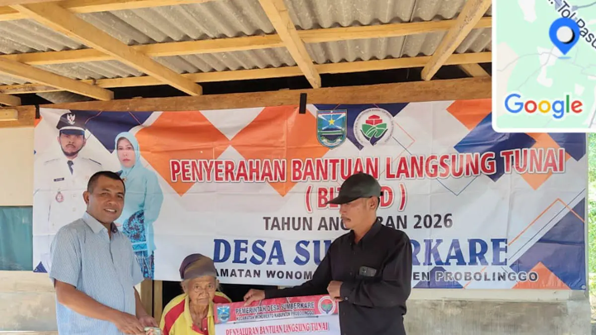 SENANG: Sekretaris Desa Sumberkare Rohmat (kanan) menyalurkan BLT DD kepada salah satu warganya di Desa Sumberkare. (Foto: Inneke Agustin/Jawa Pos Radar Bromo)