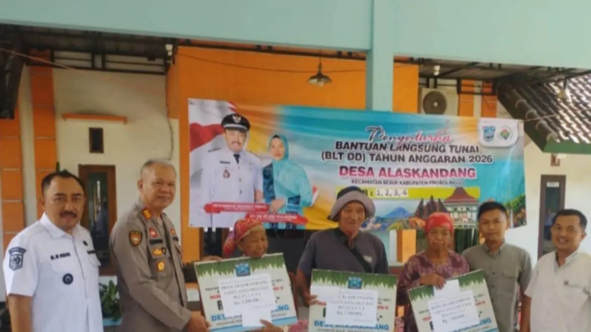 PENERIMA MANFAAT: Kepala Desa Alaskandang, Mohammad Muhibbur Ridho (kiri) menyerahkan BLT DD kepada warga. (Foto: Agus Faiz Musleh/Jawa Pos Radar Bromo)