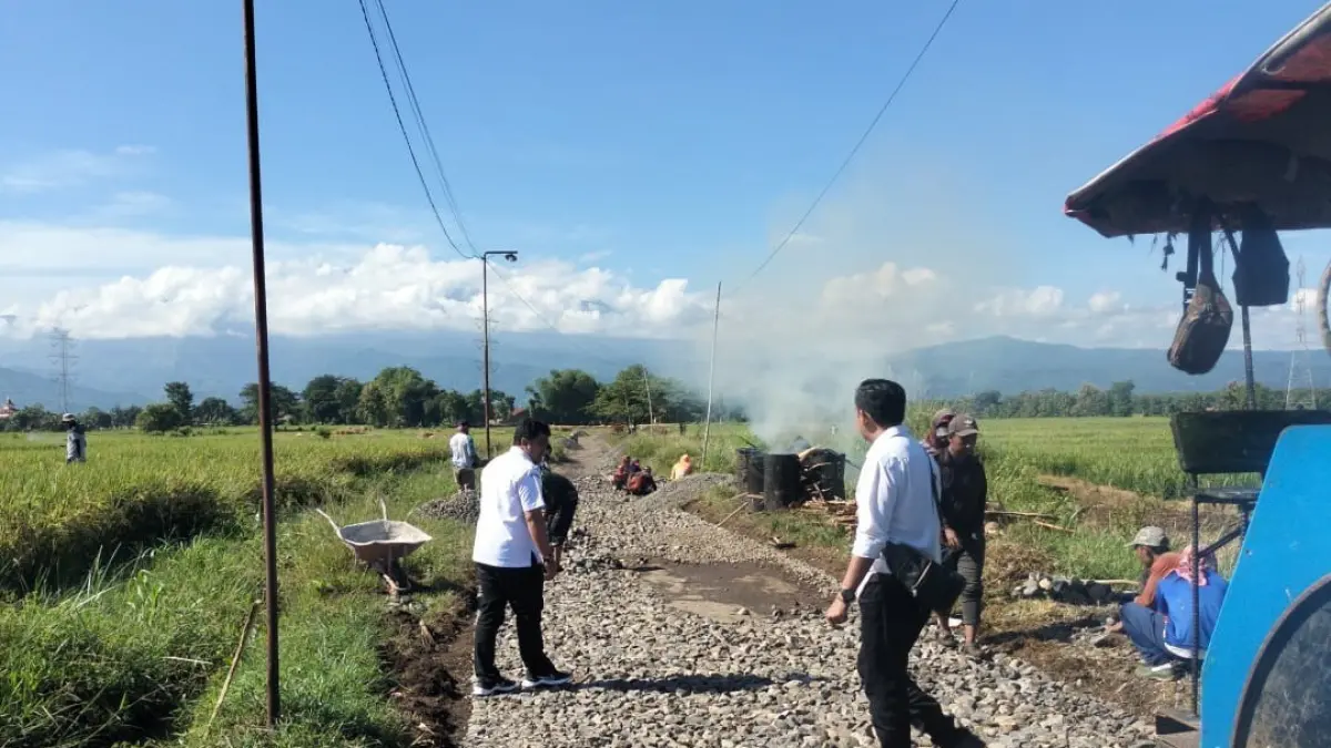 DIGARAP: Sejumlah pekerja menggarap pengaspalan jalan di Desa Matekan, Kecamatan Besuk. Proyek ini digarap menggunakan dana Bantuan Keuangan Daerah. (AGUS FAIZ MUSLEH/JAWA POS RADAR BROMO)