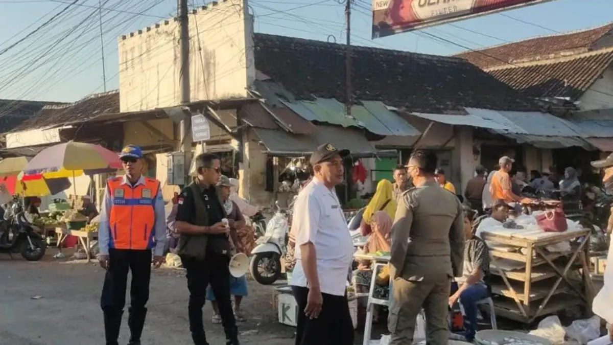 HARUS TEGAS: Personel Satpol PP Unit Kraksaan bersama Dishub dan Koordinator Pasar Semampir melakukan penertiban pedagang pasar yang masih berjualan di luar jam operasional, Rabu (8/7). (Foto: Satpol PP for Jawa Pos Radar Bromo)