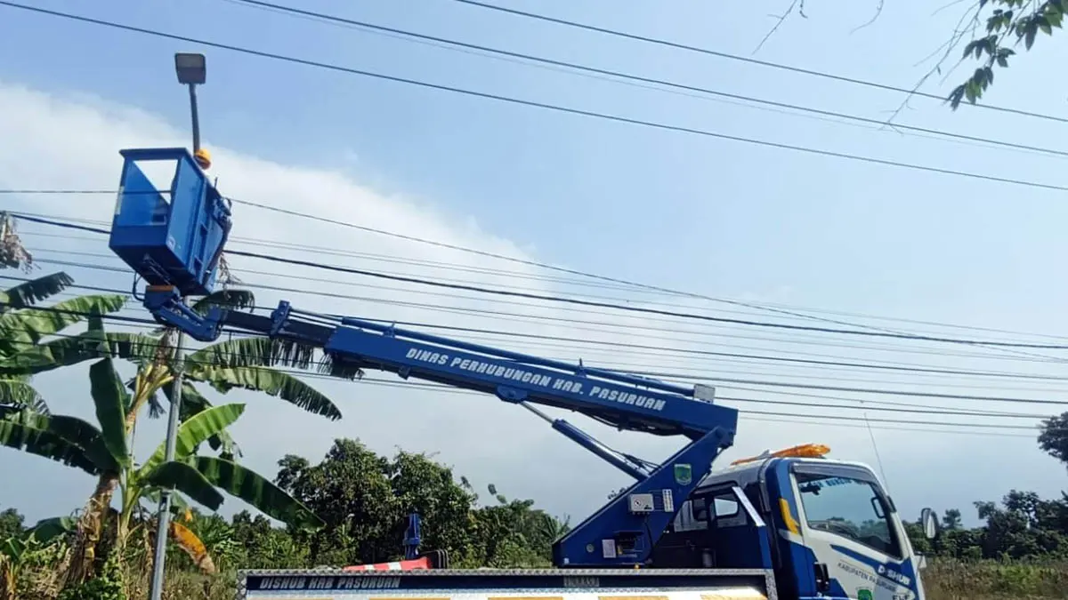BENAHI: Petugas Dishub Kabupaten Pasuruan saat melakukan perbaikan terhadap lampu PJU yang sempat mengalami kerusakan. (Pemkab Pasuruan for Radar Bromo)