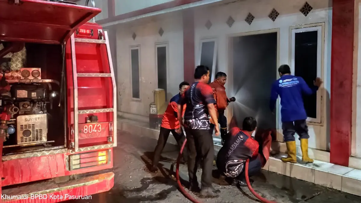 Tim Damkar saat berupaya melakukan pembasahan di bangunan milik Ketua Gerindra Kota Pasuruan yang terbakar. 