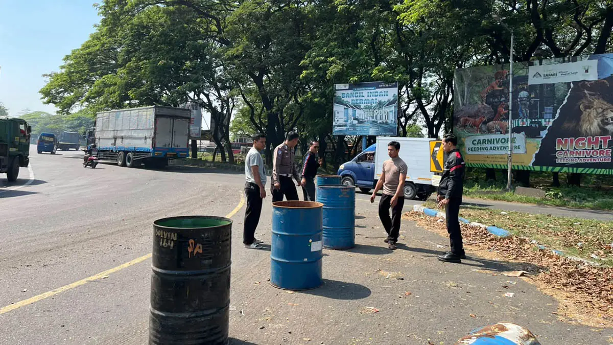 BIAR AMAN: Petugas kepolisian saat memasang road barrier berupa tong untuk pencegahan kecelakaan di Bundaran Apollo Gempol. Kawasan setempat, memang disebut-sebut titik rawan kecelakaan. (Satlantas for Radar Bromo)