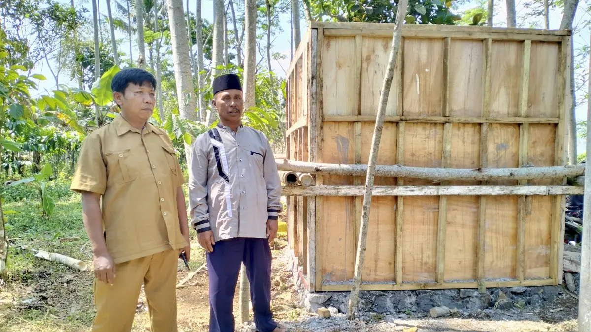 DIBANGUN: Ketua HIPPAM Jaya Raya, Desa Sumberduren Abd Rosid (Pakai Songkok) dan Kaur Umum Desa Sumberduren Durrahman mengecek tandon air yang dibangun di RT 13/RW 4, Dusun Manggisan. (Foto: Achmad Arianto/Jawa Pos Radar Bromo)