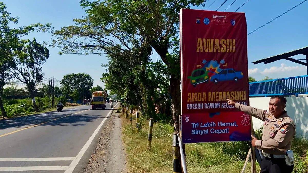 JALUR RAWAN: Petugas Satlantas Polres Probolinggo memasang papan di black spot ruas jalan pantura Kecamatan Dringu. (Foto : Achmad Arianto/Jawa Pos Radar Bromo)