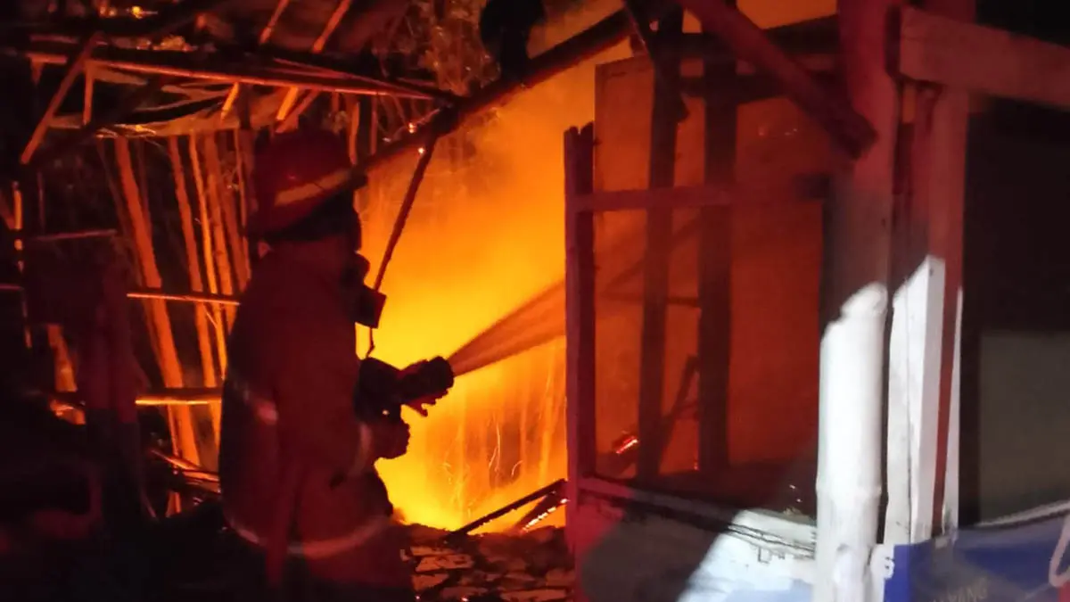 MASIH MEMBARA: Personel damkar melakukan pemadaman di lokasi kebakaran warung es degan milik Sakrim, di Desa Curah Sawo, Kecamatan Gending pada Rabu (15/7) dini hari. (Foto: Damkar for Jawa Pos Radar Bromo)